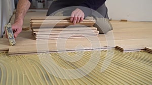 Worker installing wood parquet.