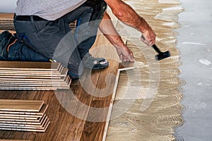 Worker installing wooden flooring boards