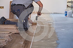 Worker installing wooden flooring boards