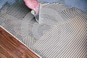 Worker installing wooden flooring boards