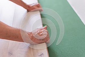 Worker installing wooden laminate flooring