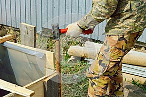 Worker installs formwork, hammer an iron pipe - support