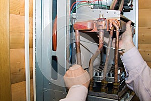 worker installs the heat exchanger after descaling on a workplace in the gas boiler