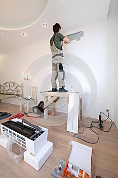 Worker installs a metal plate for fixing air photo