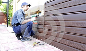 Worker installs plastic siding on the facade