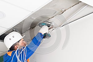 A worker installs a router on the wall to transmit the Internet signal in offices and homes