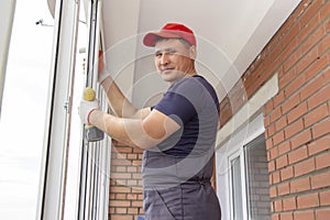 Worker installs window master sverdit frame to attach to  base repair in high-rise building