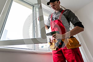 Worker installs windows master sverdit frame to attach to the base repair in high-rise building