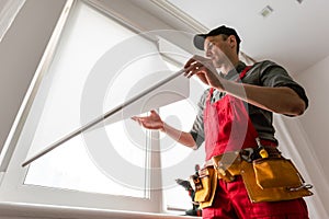 Worker installs windows master sverdit frame to attach to the base repair in high-rise building