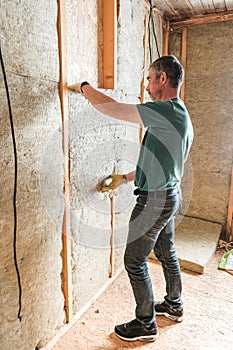 Worker insulates a country house of mineral wool