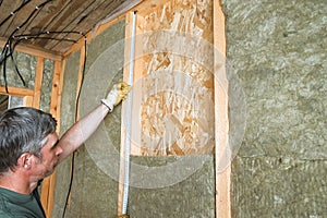 Worker insulates a country house of mineral wool