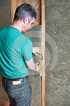 Worker insulates a country house of mineral wool