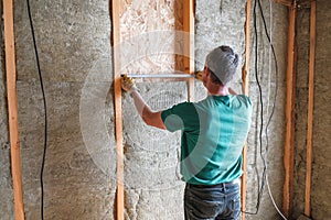 Worker insulates a country house of mineral wool