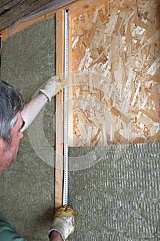 Worker insulates a country house of mineral wool