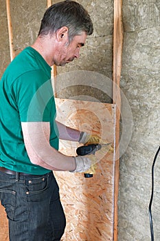 Worker insulates a country house of mineral wool