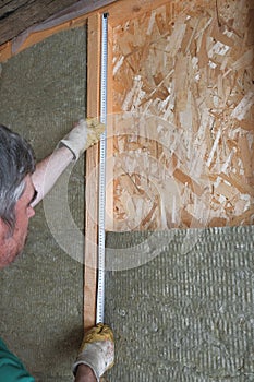 Worker insulates a country house of mineral wool