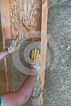 Worker insulates a country house of mineral wool