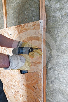 Worker insulates a country house of mineral wool