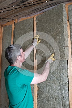 Worker insulates a country house of mineral wool