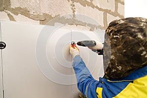 The worker insulates the house from foam plastic