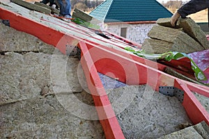 The worker insulates the roof with a mineral wool