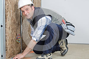 Worker insulates wall with mineral wool