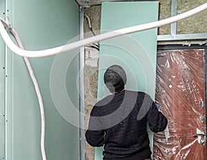 The worker insulates the walls with drywall