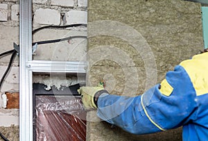 The worker insulates the walls with drywall