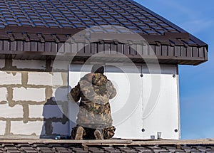 Worker insulates the walls of the house with plastic panels