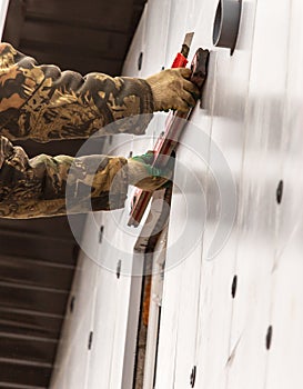 Worker insulates the walls of the house with plastic panels