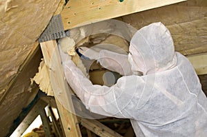 Worker insulating a roof