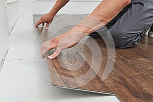 Worker joining vinyl floor covering at home renovation