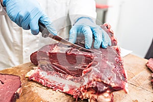 Worker from knife cutting meat in a meat shop