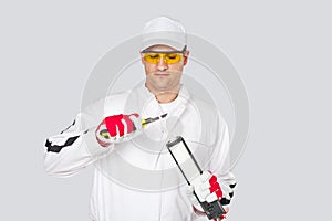 Worker with knife remove cut cap sealant silicon photo