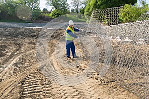 Worker knits a net for the bottom of an artificial lake