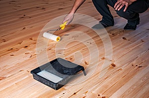 Worker lacquers the wooden floor