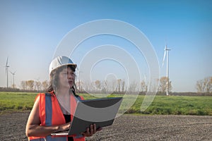 Worker with laptop in wind farm