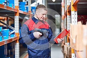 Worker with laser barcode scanner at warehouse