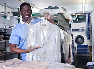Worker of laundry showing clean clothing