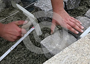 Worker laying paving stones