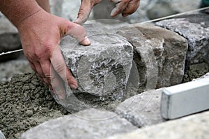 Worker laying paving stones