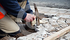 Worker laying paving stones