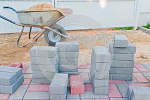 Worker laying red and gray concrete paving blocks. Road Paving, construction