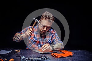 Worker of leather creating new leatherwork at studio