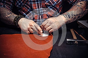 Worker of leather producing leather goods