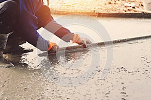 worker leveling concrete pavement for mix cement at construction