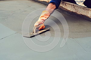 worker leveling concrete pavement for mix cement at construction