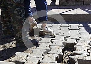 A worker  lifts paving slabs.
