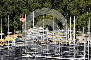 Worker loading PVC concrete wall formwork on new social housing home unit block at 56-58 Beane St. Gosford, Australia. April 10,