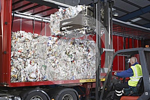 Worker Loading Stacks Of Recycled Papers On To Lorry